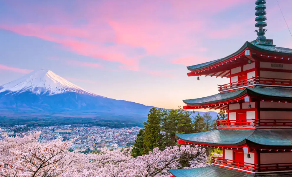 Things to do in Japan - a sunset landscape with a temple and mountain in the background