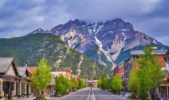 A view down a street in Banff with mountains in the background